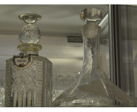 A ship's decanter, with etched foliate decoration, together with a square cut glass decanter with ceramic whisky label (2)