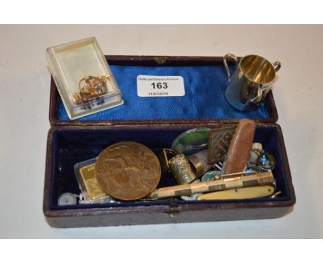 A small leather box containing a rolled gold propelling pencil, thimbles, a medallion etc.