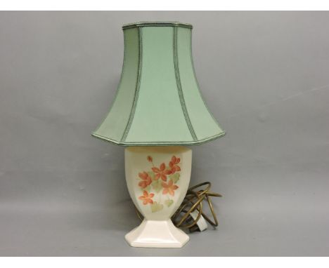 A Moorcroft lamp base, with pink flowers, on a cream ground, and a green shade