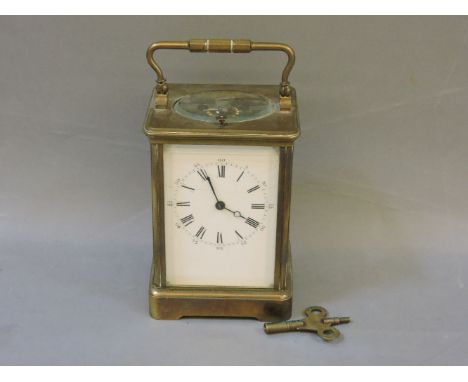 A late 19th century French brass carriage clock, with repeating action, enamel dial with Roman and Arabic numerals, chiming o