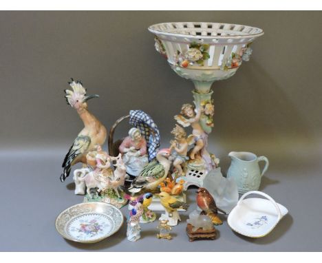A European porcelain centrepiece, decorated with putti, a Meissen style figure of a lady riding a goat, a Herend bird, and ot