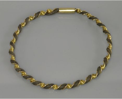 An Indian twisted bangle, entwined with elephant hair, tested as approximately 9ct gold