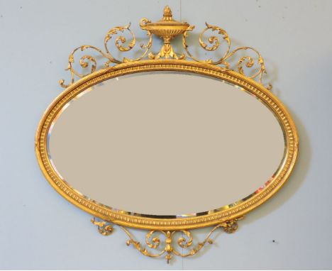 A 19th century oval gilt framed mirror, with urn and scrolling acanthus leaf crest, 104cm wide, 104cm high