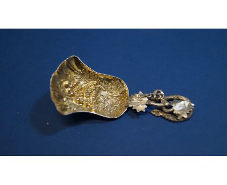 A unmarked caddy spoon, having floral decoration and gilded bowl, 8cm.