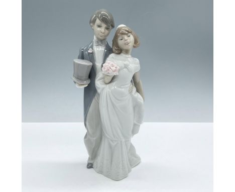 Glossy porcelain, depicts a young couple on their wedding day, modeled in white and blue pale colors. Lladro backstamp. Artis