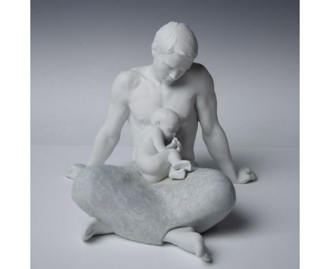 Matte and lightly glazed porcelain figure of a seated man looking down lovingly at his infant child. Lladro backstamp. This i