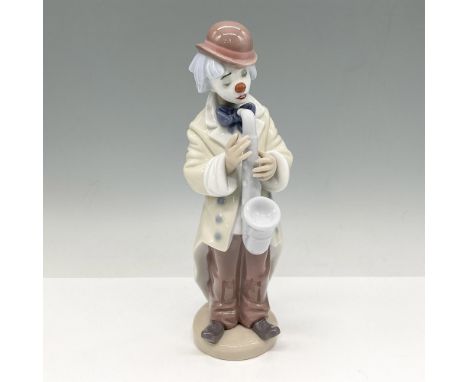 Glossy figural colored in browns, blue and cream playing his instrument. Lladro backstamp. Artist: Francisco CatalaIssued: 19