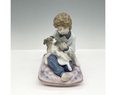 Glossy figural on cushion training his dog. Soft coloration of rose, blue, gray and white. Lladro backstamp. This item has it