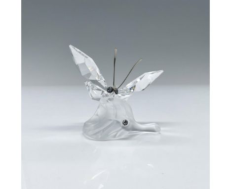 Brilliant clear crystal figurine of A delicate faceted butterfly in clear crystal daintily flits over a frosted crystal leaf.