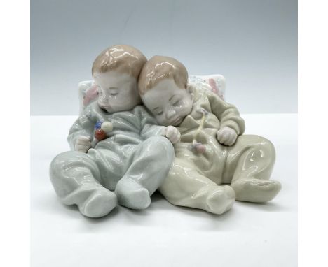 Glossy, hand made porcelain made in a pale pastel color palette. Showcases a heartwarming scene of two babies dressed in shad