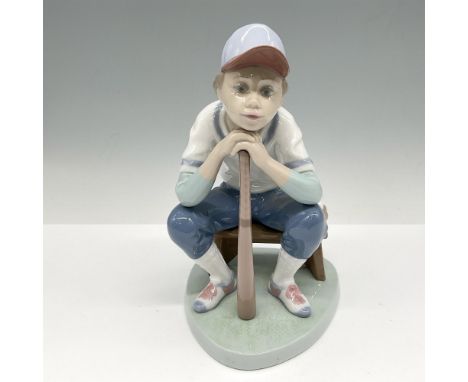 Glossy figural daydreaming of the game. Colored in blue, white and rust. Lladro backstamp. Artist: Joan CoderchIssued: 1994 -