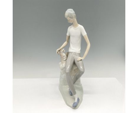 Sitting figural with dog colored in brown, white and grey with glossy finish. Nao by Lladro backstamp. Issued: 20th centuryDi
