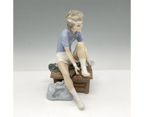 Glossy figural with all his tennis gear readying for a match. Nao by Lladro backstamp. Issued: 20th centuryDimensions: 4.5"L 