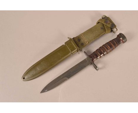 A US M4 Combat/Fighting knife by Camillus, having makers name to the cross guard, leather washer grip, complete with M8A1 sca