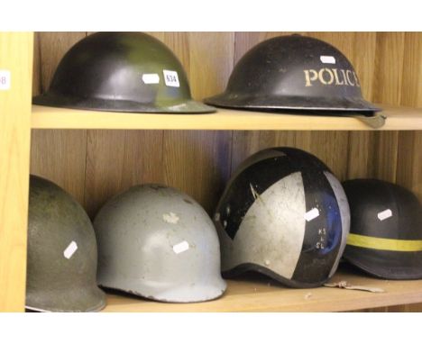 A Vintage Military Police Helmet, one other British Helmet, Two US Helmets and two others 