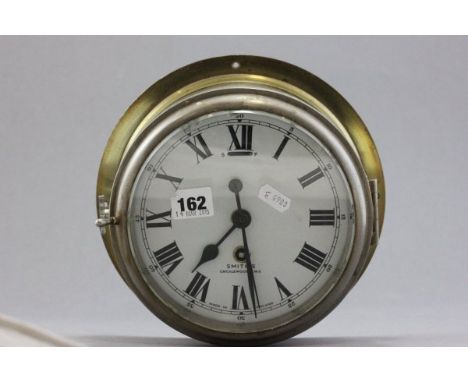 A Brass Ships Bulkhead Clock, the white enamel face marked Smiths, Cricklewood W.2 with a start/finish aperture 