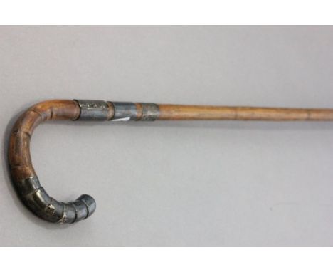 An Early 20th century Walking Stick with bamboo effect shaft plus silver tips and bands