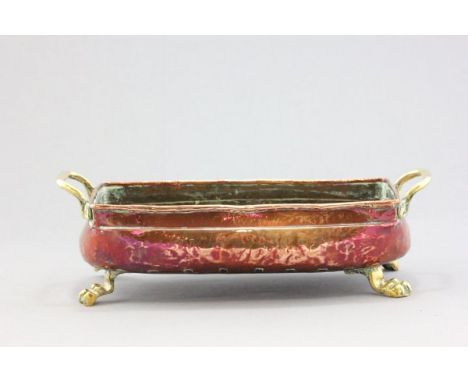 An Antique Copper Planter with brass handles and feet 