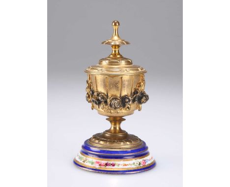 A 19TH CENTURY GILT-METAL AND ENAMEL INKWELL in the form of an urn, with hinged cover, relief decorated with floral swags. 11