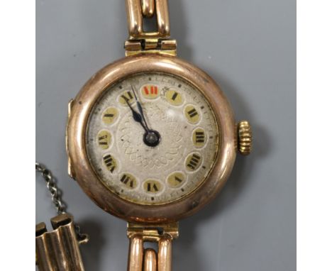 A lady's early 20th century 9ct. gold manual wind wrist watch on a 9ct gold bracelet.