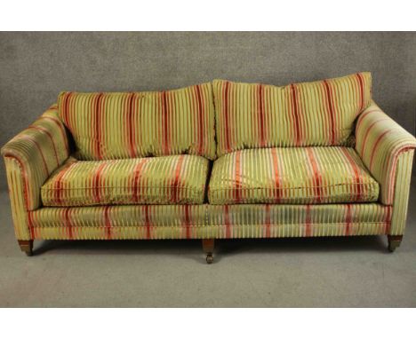 A large contemporary sofa, upholstered in striped fabric with tapering block feet terminating in brass caps and castors. H.80