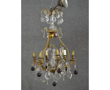 An early 20th century gilt brass six branch chandelier with crystal flowers and drops and purple glass spheres. H.67 W.40cm 