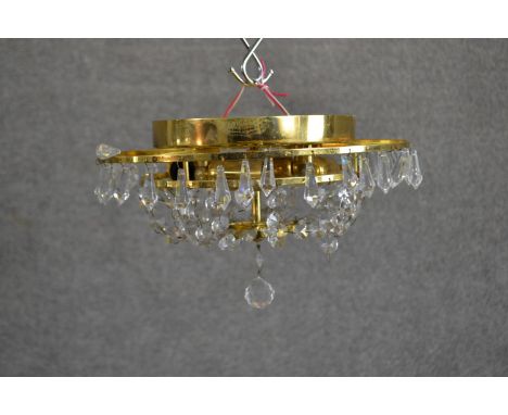 A contemporary circular tiered brass ceiling light, hung with faceted glass lustres. Diam.32cm 