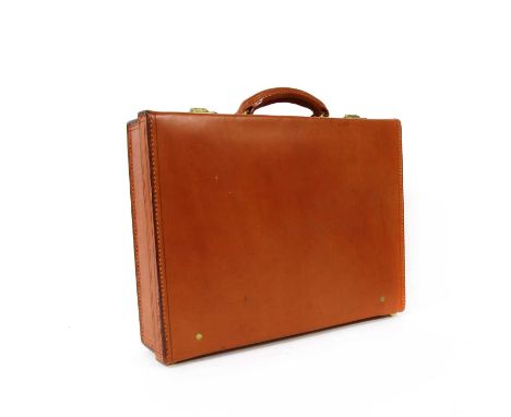 A Swaine Adeney tan leather briefcase, single rolled handle, brass hardware, dual lock opening to sectioned interior to top, 