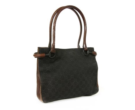 A Gucci dark brown canvas curved handle bag, dual rolled leather handles and edging, horse bit detailing, magnetic closure op