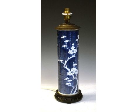 Chinese blue and white porcelain lamp decorated with prunus, raised on hardwood stand, 41cm high including fitment.