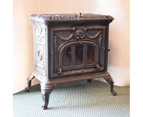 Cast metal burner, 68cm high x 62cm x 50cm overall including outlet pipe.