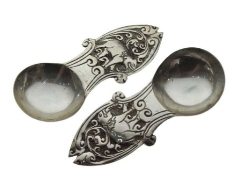 Pair of Indian white metal caddy spoons with circular bowl and chased elephant decoration to the handle, marked SS, 8.5cm lon