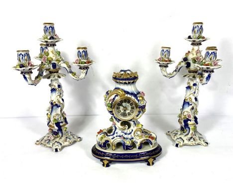 A Meissen style ceramic clock garniture, 20th century, with a pair of four light candelabra, the French style clock with Roco