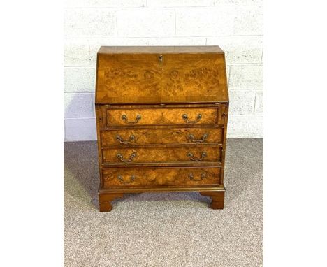 A Georgian style walnut veneered bureau, with sloping fall front, and four drawers 95cm high, 76cm wide and 40cm deep