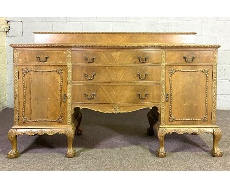 A Georgian style mahogany veneered sideboard, with arrangement of cupboards and drawers on claw and ball feet