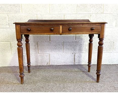 A Victorian two drawer side table, with rounded rectangular top and set on four ring turned and tapered legs