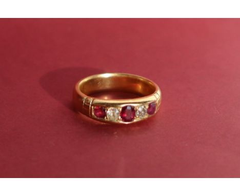 A ruby and diamond five stone ring set with three rubies and two round old cut diamonds to a yellow metal setting and shank, 