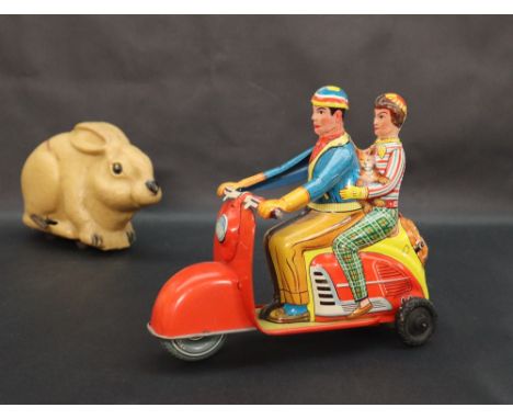 A Marke Technofix tin plate scooter GE-292 with two figures and a dog on red vespa type scooter together with a clockwork rab