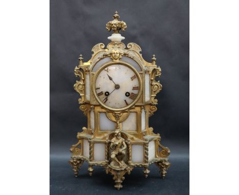 A 19th century ormolu and hardstone clock with a mask and vase finial, scrolling leaves and seated figure, the movement marke