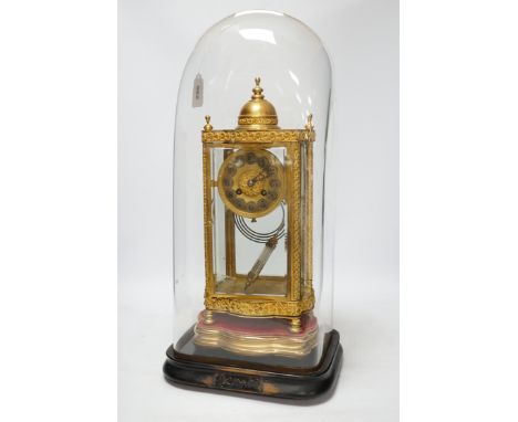 A French four glass mantel clock striking on a coiled gong with gilt brass frame and mercury pendulum, on a stand under a gla
