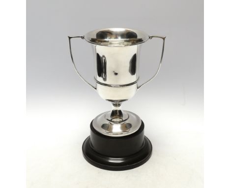 A George V unengraved silver two handled trophy cup, W H Haseler Ltd, Birmingham, 1929, height 17.6cm, 9.5oz, on an ebonised 