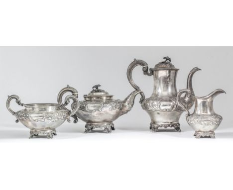 An early Victorian silver three-piece tea service, the circular squat bodies with moulded rims, embossed with scroll cartouch