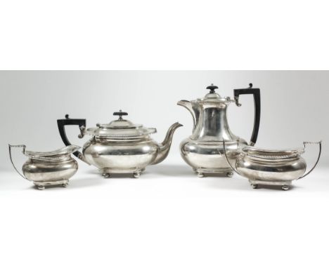 A George V silver rectangular four-piece tea service of bulbous form with gadroon, shell and scroll cast mounts, angular loop