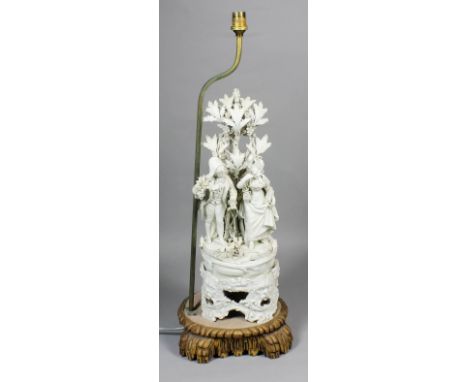 An Italian white creamware pottery group of a couple in early 19th Century dress, with bocage, on a pierced stand with lion m