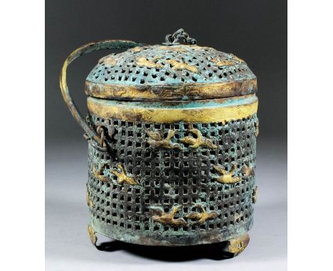 A Chinese bronze and parcel gilt cylindrical basket and domed cover, the pierced cover and sides cast with birds, on three le