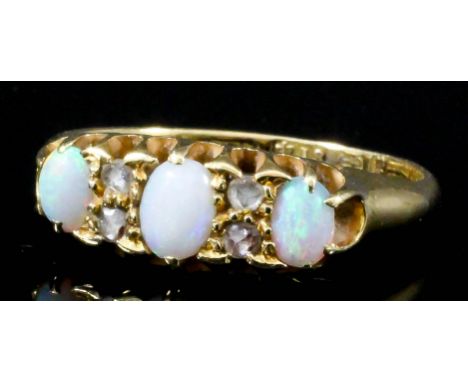 An 18ct gold mounted three stone opal ring, set with three oval opals interspersed by white stones (size O - gross weight 3.3