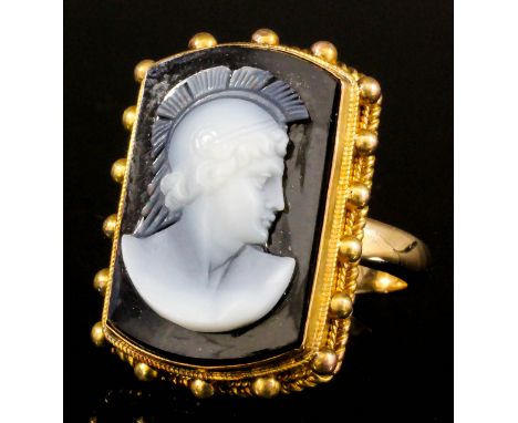 A 19th Century Continental gold metal mounted hardstone intaglio ring, the face set with a rectangular panel carved in white 