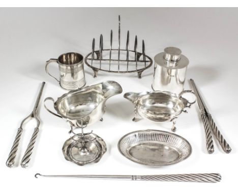 A George III silver oval six-division toast rack with circular disc pattern finial, in four scroll feet, 6.5ins x 4.5ins x 5.