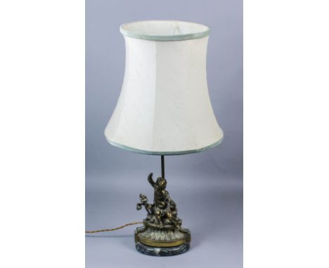 A French gilt brass electric table lamp modelled as a seated putti, on oval green marble base, and shade for same