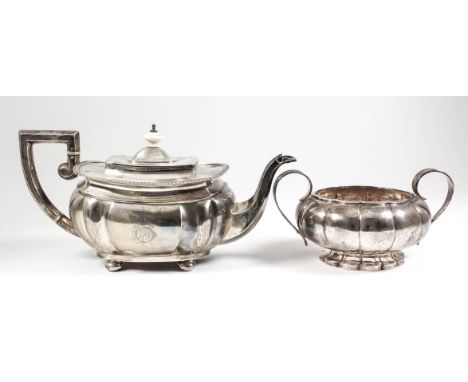 A George V silver rectangular teapot with gadroon mounts, lobed body, angular handle, carved ivory finial, on four flat bun f